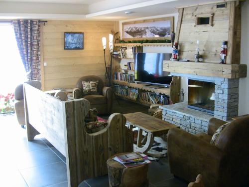 un salon avec une télévision et une cheminée dans l'établissement Alpine Lodge 1, aux Contamines-Montjoie
