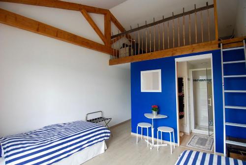 a bedroom with a bed and a blue wall at Maison d'Hôtes des 2 Chênes in Bessenay