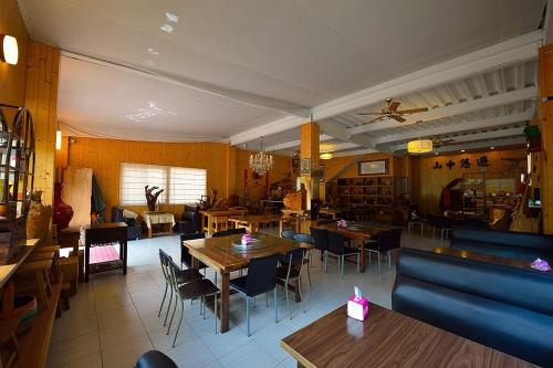 um restaurante com mesas e cadeiras num quarto em Shan Jhong You You B&B em Lugu