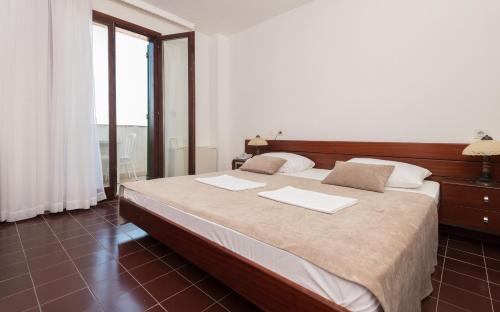 a bedroom with a large bed with two pillows on it at Hotel Zenit Neum in Neum