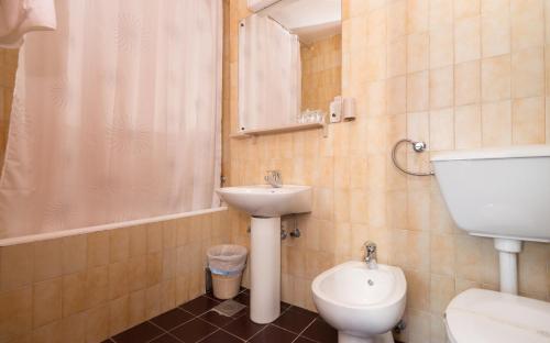 y baño con lavabo, aseo y ducha. en Hotel Zenit Neum, en Neum