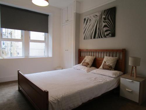 グラスゴーにあるWestend Glasgow Apartmentのベッドルーム1室(ベッド1台付)、壁にシマウマの絵が飾られています。