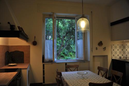 ピオンビーノにあるAppartamento di pregioのキッチン(テーブル付)、大きな窓が備わります。