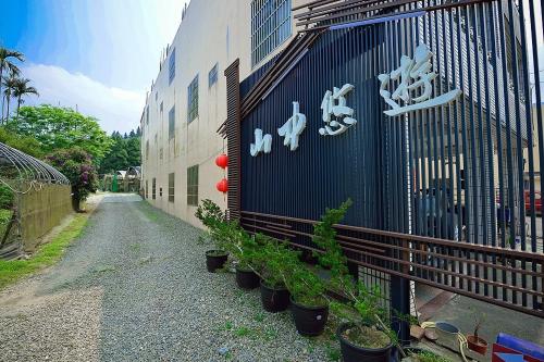 a building with potted plants on the side of it at Shan Jhong You You B&B in Lugu
