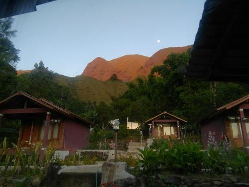 a group of houses with mountains in the background at Sembalun Kita Cottage in Sembalun Lawang