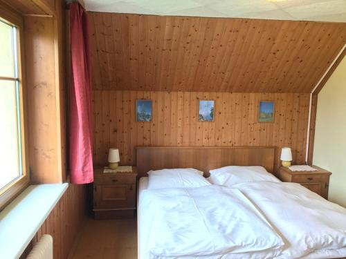 Un dormitorio con una cama con una pared de madera. en Austrian Alps - Haus Kienreich, en Altenmarkt im Pongau