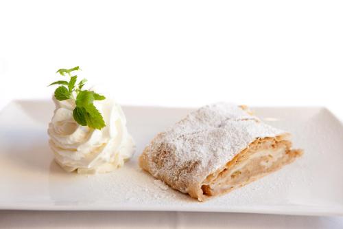 a piece of cake and whipped cream on a plate at Hotel Walliserstube in Damuls
