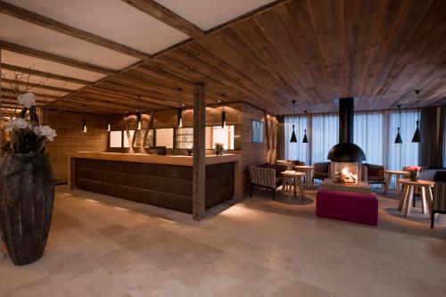 a living room with a fireplace and tables and chairs at Hotel Walliserstube in Damuls