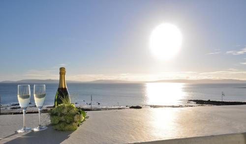 a bottle of wine and two glasses on the beach at Salthill Hotel in Galway