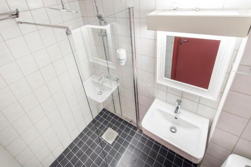 a white bathroom with a sink and a mirror at Trysil Hotel in Trysil