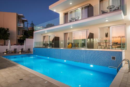 a villa with a swimming pool in front of a building at Panorama+ in Almirida