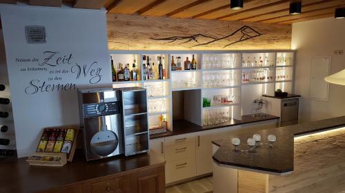a kitchen with a refrigerator and a counter with wine bottles at Hotel Garni Wolfgang in Saalbach Hinterglemm