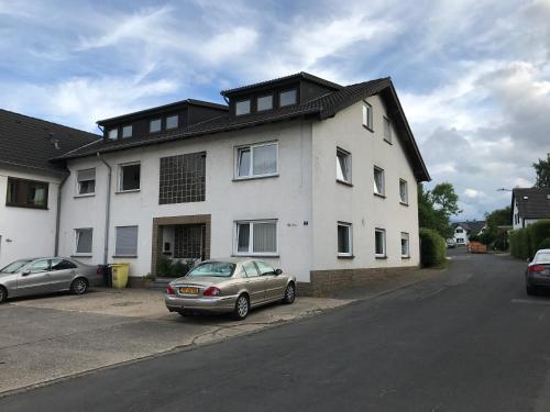 a white house with two cars parked in front of it at Gästehaus Fries in Blankenheim