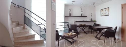 a living room with a staircase and a table and chairs at Hotel South Charleroi Airport in Charleroi