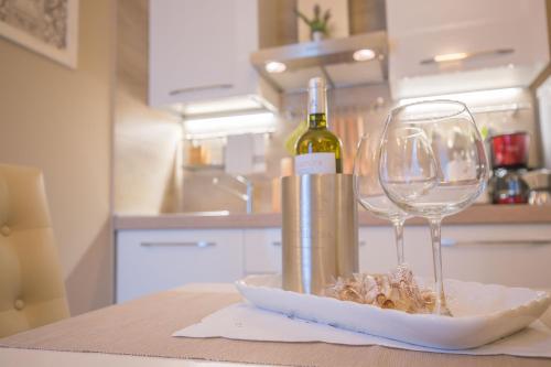 una botella de vino y una copa de vino en una mesa en Edonè Holiday Home, en Siracusa