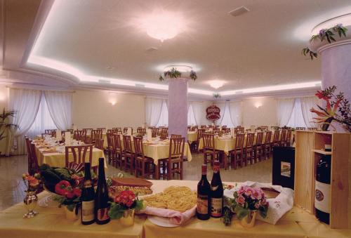 a banquet hall with tables and chairs with wine bottles at Hotel Ristorante Pedrocchi in San Giorgio di Perlena