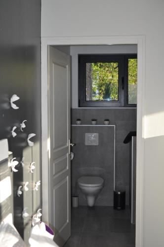 une salle de bain avec toilettes et fenêtre dans l'établissement Au Cœur du Jardin, à Lille