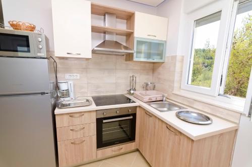 a kitchen with a sink and a refrigerator at Luxury Villa Star Lights Trogir - heated pool, hot tub, gym, billiard in Trogir