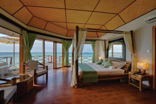 a bedroom with a bed with a view of the ocean at Safari Island in Mushimasgali