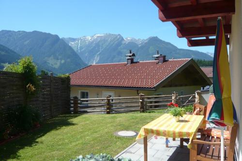 a house with a fence and a table in a yard at Appartement Wildkogel in Neukirchen am Großvenediger