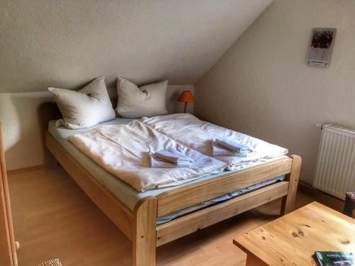 Schlafzimmer mit einem Bett mit weißer Bettwäsche und Kissen in der Unterkunft Waldhaus Crottendorf in Crottendorf