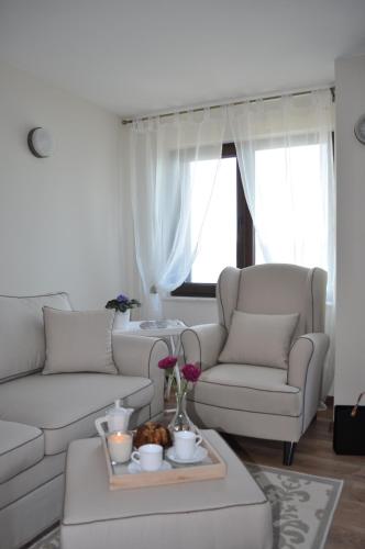 a living room with a white couch and a table at Villa Elea in Nesebar