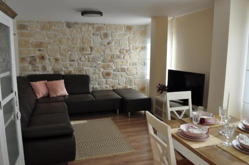 a living room with a black couch and a table at Villa Elea in Nesebar