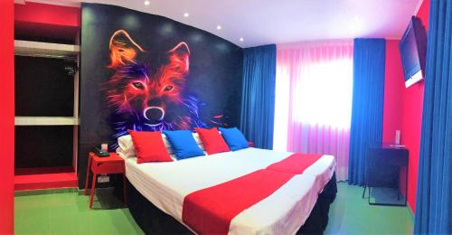 a bedroom with a bed with a painting of a wolf at Hotel Indiana in Pinto