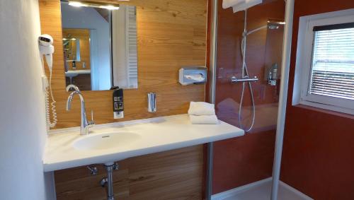 ein Bad mit einem Waschbecken und einer Dusche in der Unterkunft Gasthof Schallerwirt in Krakauebene