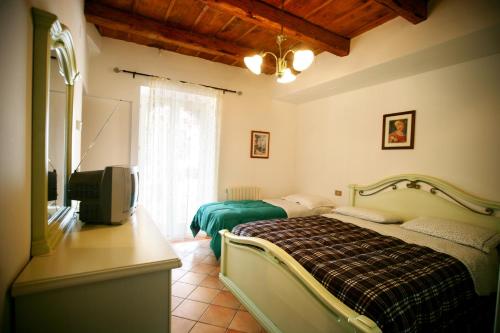 um quarto com uma cama e uma televisão de ecrã plano em Agriturismo Azzurro em Osimo
