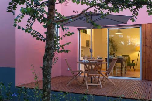 a patio with a table and chairs on a deck at Quinta dos Peixes Falantes in Ribeira Grande