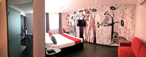 a hotel room with a bed and a red couch at Hotel Indiana in Pinto