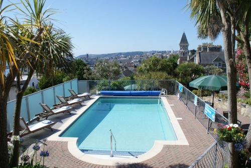 uma piscina com espreguiçadeiras e um guarda-sol em Hotel Penzance em Penzance