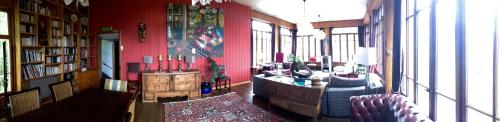 a room with a red wall with a table and chairs at Hotel de la Sage in La Sage