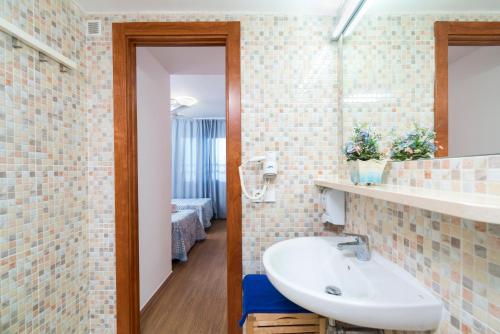 La salle de bains est pourvue d'un lavabo et d'un miroir. dans l'établissement Apartaments Els Llorers, à Lloret de Mar