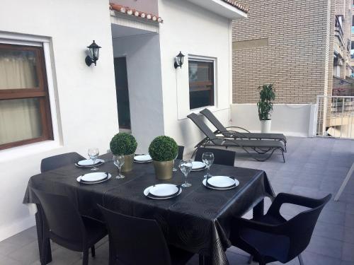 - une table et des chaises noires sur la terrasse dans l'établissement Apartamento Cocoa, à Oropesa del Mar