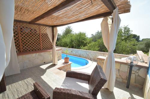 een patio met een zwembad en een pergola bij Villa Lumari in Siracusa