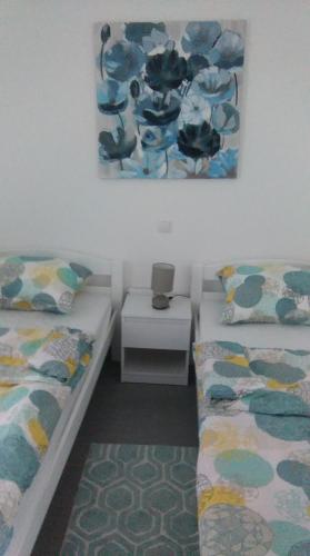 a bedroom with two beds and a picture on the wall at Apartmani Vila Dadić in Karlobag