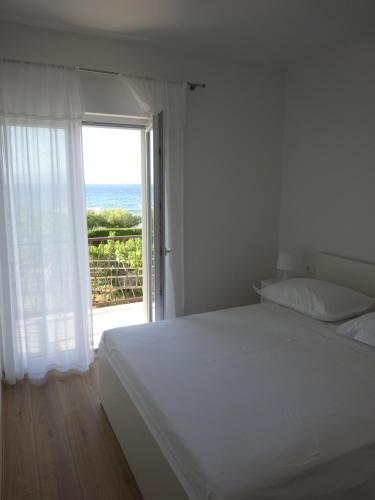 a bedroom with a bed and a window with the ocean at Apartment Duce in Omiš