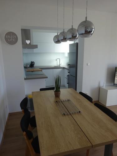 a dining room table with chairs and a kitchen at Apartment Duce in Omiš