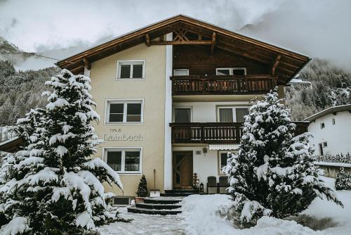 un gran edificio con un balcón en la nieve en Haus Rainbach, en Umhausen