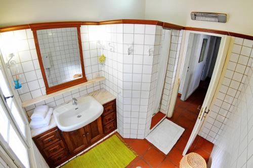 a small bathroom with a sink and a mirror at Domus Nostos in Apolpaina