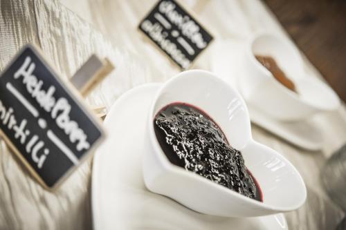 a person is holding a heart shaped bowl of chocolate at Hotel Bergland in Cadipietra