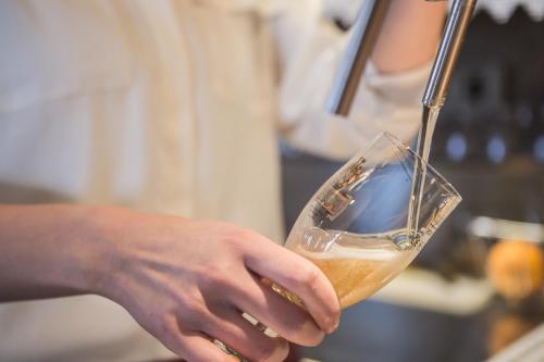 a person is holding a glass of wine at Hotel Bergland in Cadipietra