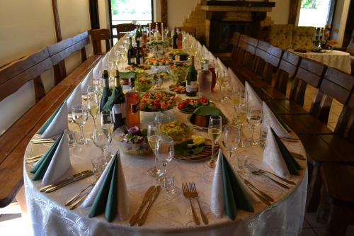 a long table with plates of food and wine glasses at Sodyba Tarp Liepų in Leliūnai
