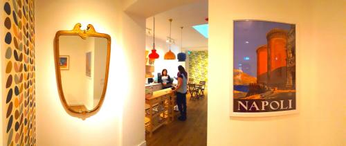 a mirror on a wall next to a woman in a store at Napoli Tree - Lungomare in Naples