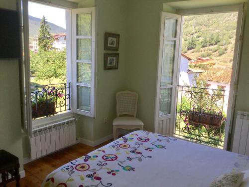 a bedroom with a bed and two windows at Villa Elena in Potes
