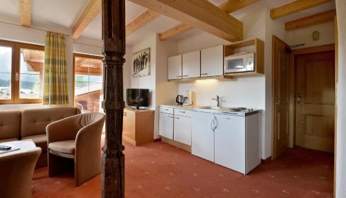 a kitchen with white appliances and a living room at Appartements am Römerweg in Oberndorf in Tirol