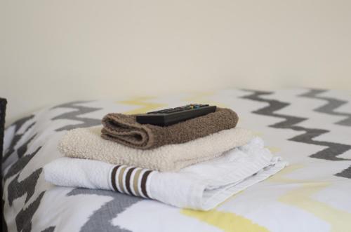 a remote control sitting on top of towels on a bed at Pretoria Guest House in Bridlington