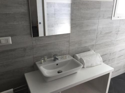 a bathroom with a white sink and a mirror at Guest House Suite in Olbia